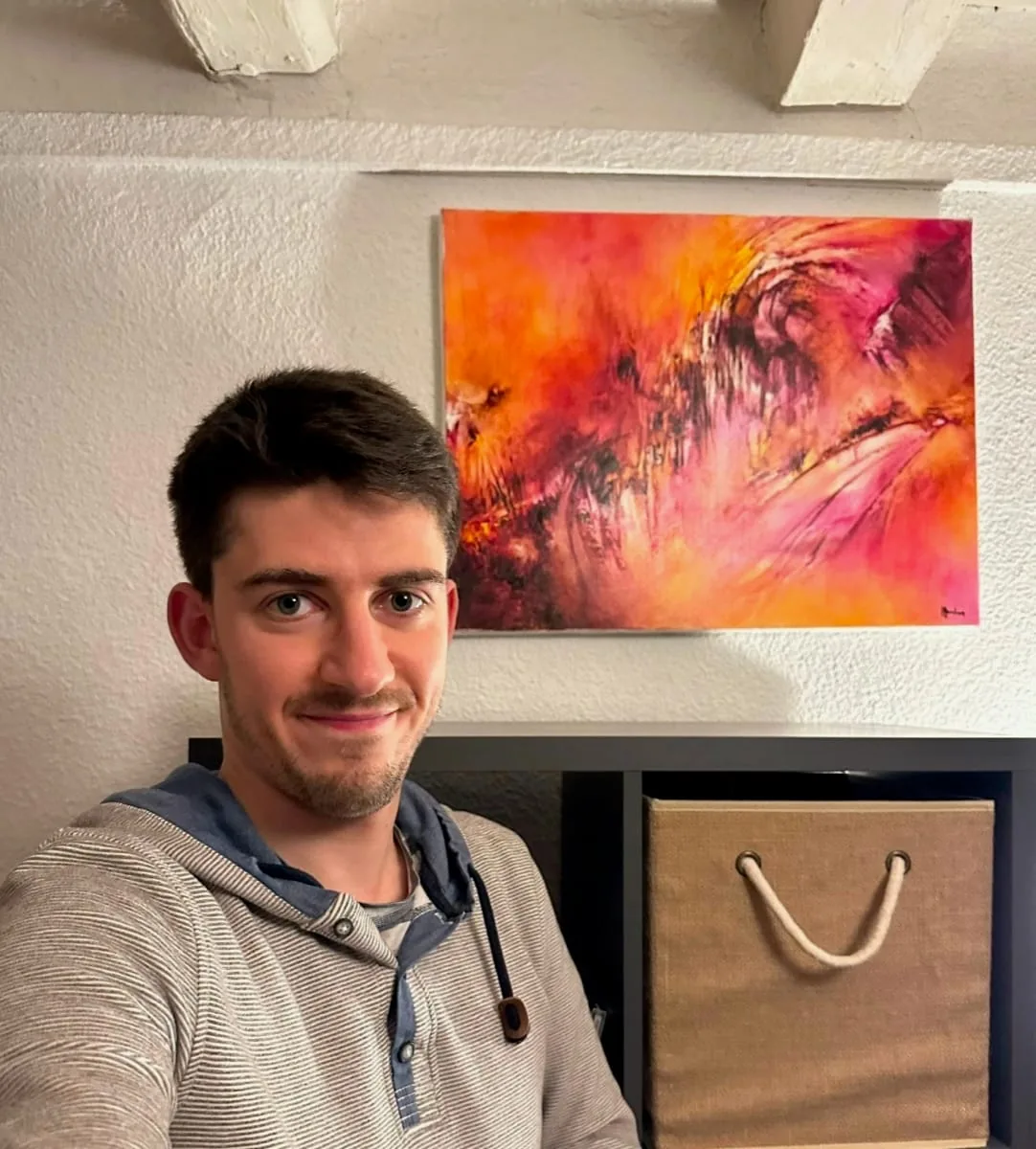 Lucas vor seinem abstrakten Bild in Orange und Rosa von Régine Gardan, in seinem Wohnzimmer in Lyon