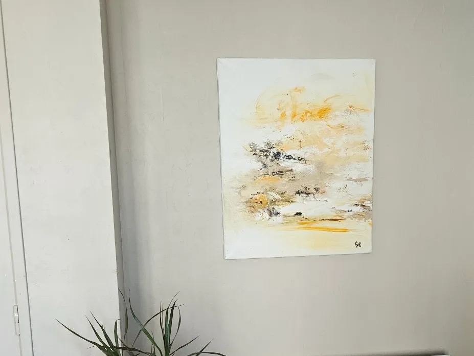 Tableau abstrait jaune et blanc de Régine Gardan accroché au mur, chez Anne